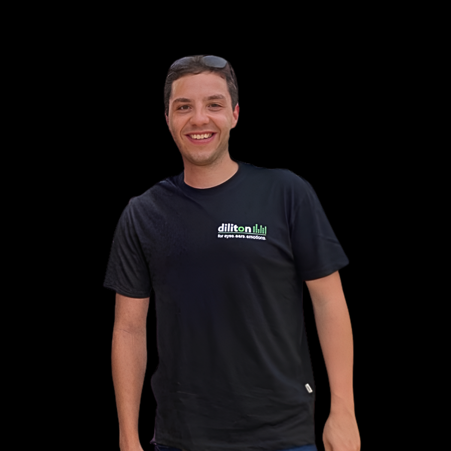 Ein Porträt von Christoph, Veranstaltungstechniker für Ton- und Lichttechnik bei der diliton GmbH, vor einem tiefschwarzen Hintergrund. Der junge Mann mit kurzen, dunklen Haaren und einer Sonnenbrille auf dem Kopf blickt lächelnd direkt nach vorne. Er trägt ein schwarzes Firmen-T-Shirt mit dem grünen diliton-Logo und dem Slogan „for eyes.ears.emotions.“ auf der linken Brust.