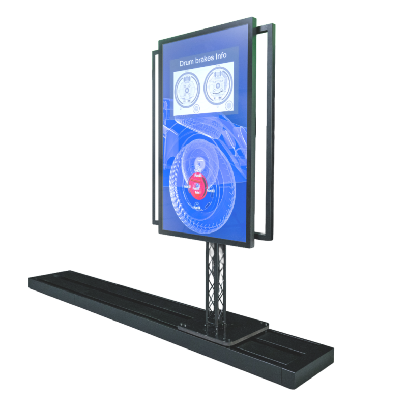 Das Bild zeigt das freistehende Sliding-Screen-System vor einem weißen Hintergrund. Ein großer, vertikal ausgerichteter Flachbildschirm mit Touch ist auf einer schwarzen Traversenstütze montiert, die sich auf einer flachen, länglichen Bodenschiene befindet. An den Seiten des Monitors sind schwarze Haltegriffe angebracht, mit denen das Display manuell verschoben werden kann. Der Bildschirm ist eingeschaltet und zeigt unter der Überschrift „Drum brakes Info“ eine blaue Infografik mit technischen Zeichnungen und Diagrammen zu Trommelbremsen.