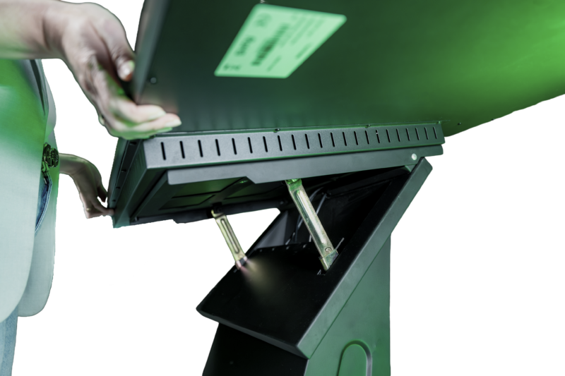 Nahaufnahme des Verstellmechanismus unter dem Display eines Touch-Terminals. Hände greifen den Bildschirmrahmen, um die Neigung über zwei metallische Gelenkstreben und Führungsschienen anzupassen.